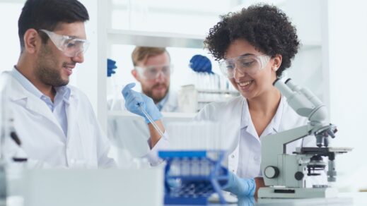 Three researchers in lab smiling