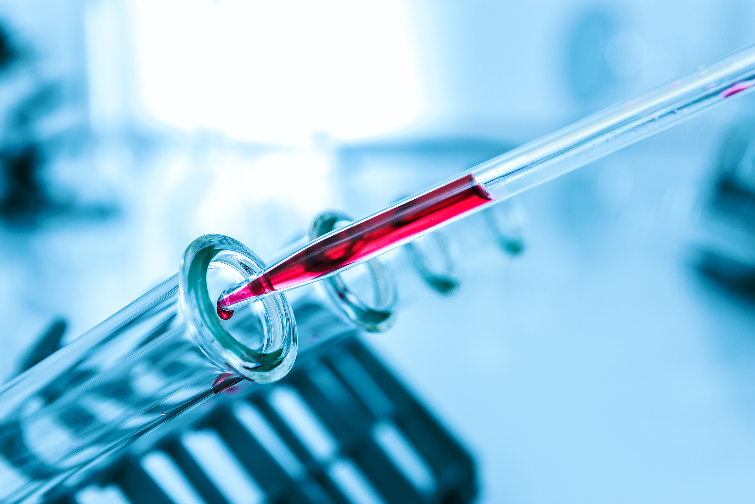 test tube receiving vial of blood from pipette