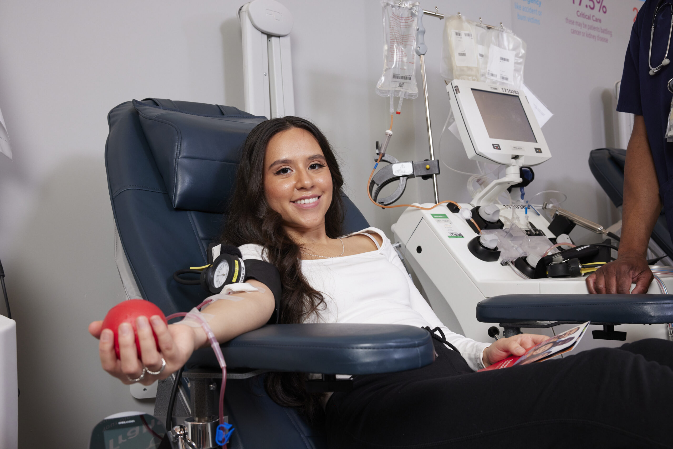 young woman donating blood squeezing a foam ball