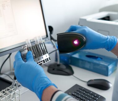 New York Blood Center Enterprises technician scanning bar code on research product.